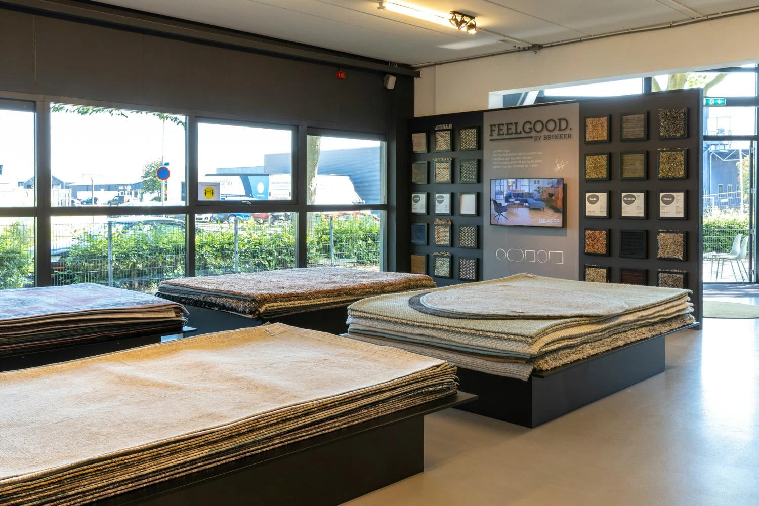Stacked rug displays beside the Feelgood by Brinker sample wall in the Volero Lekkerkerk showroom